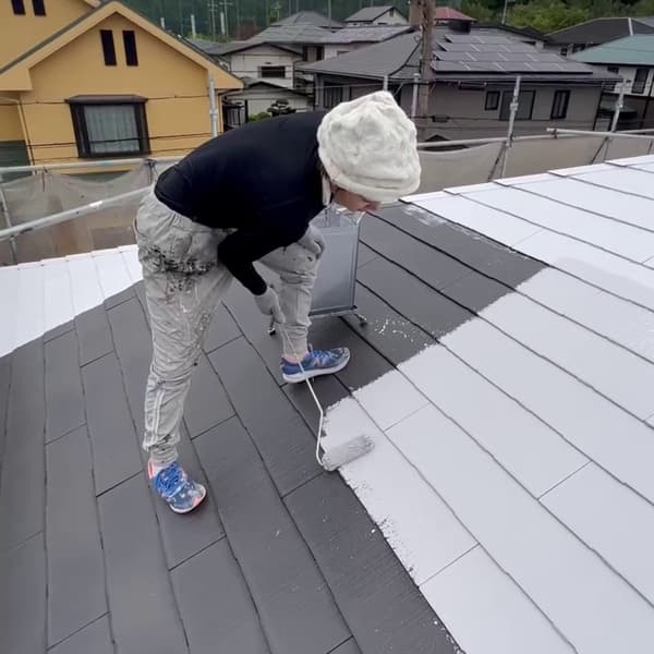 女性職人の屋根塗装作業風景