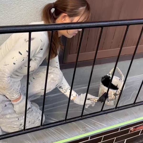 女性職人の手すり塗装作業風景